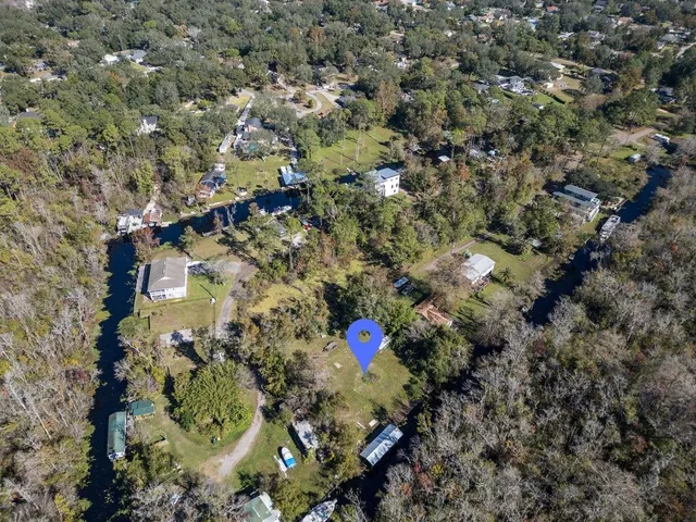 a aerial view of a house with a yard and large trees