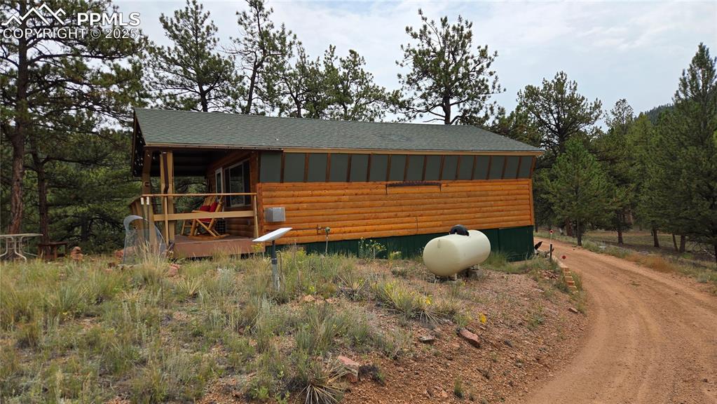 259 Vermillion Road Lake George, CO 80827 - Photo 23 of 46 a backyard of a house with table and chairs under an umbrella