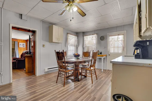 a living room with furniture ceiling fan and a large window