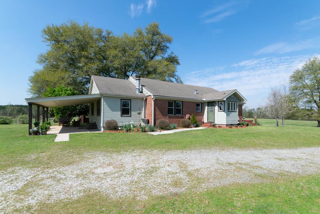 193 Padgetts Road Seale, AL 36875 - Photo 49 of 49 a front view of a house with a garden and trees