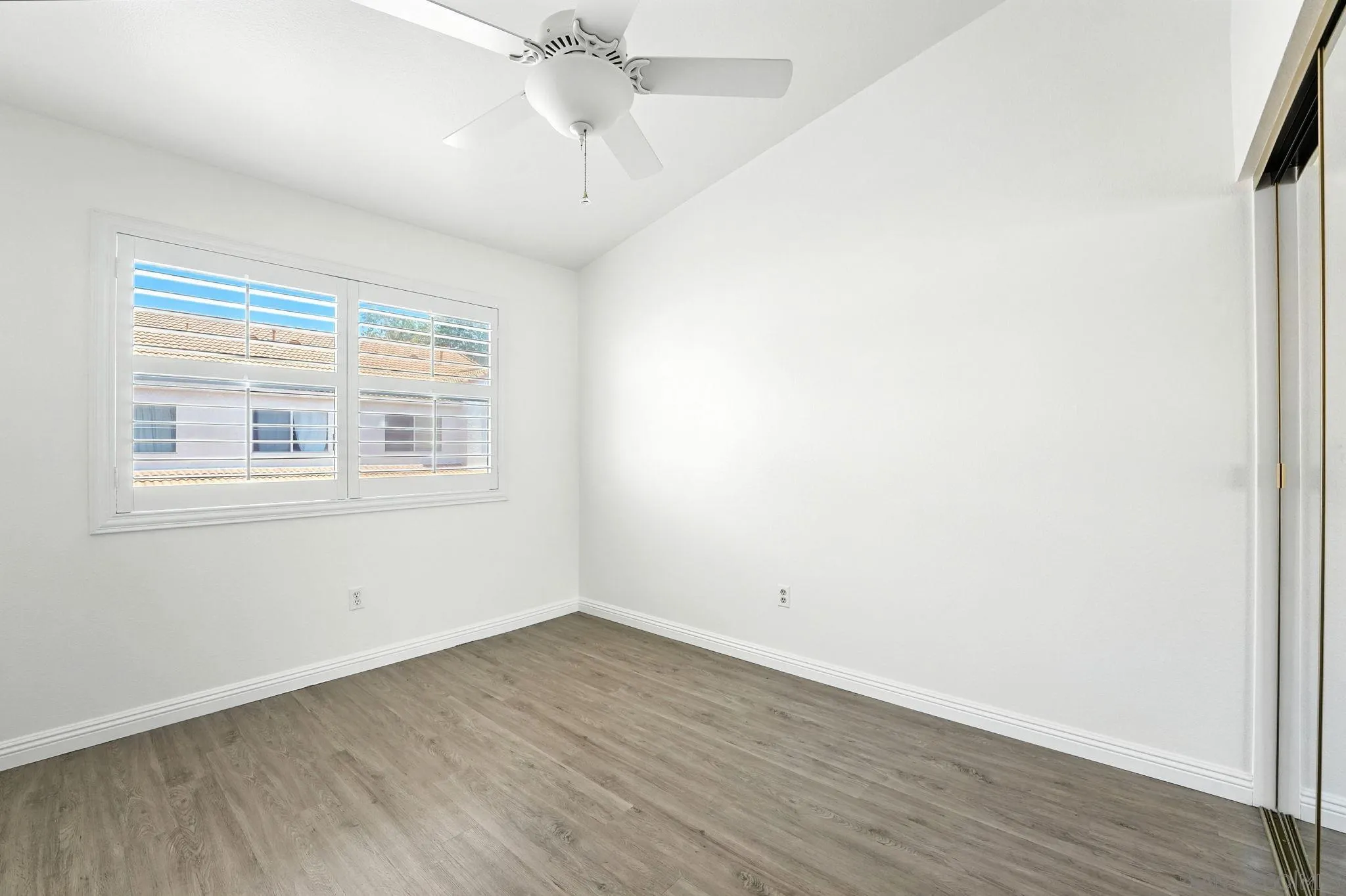 29581 Cara Way Temecula, CA 92591 - Photo 18 of 24 an empty room with wooden floor chandelier fan and windows