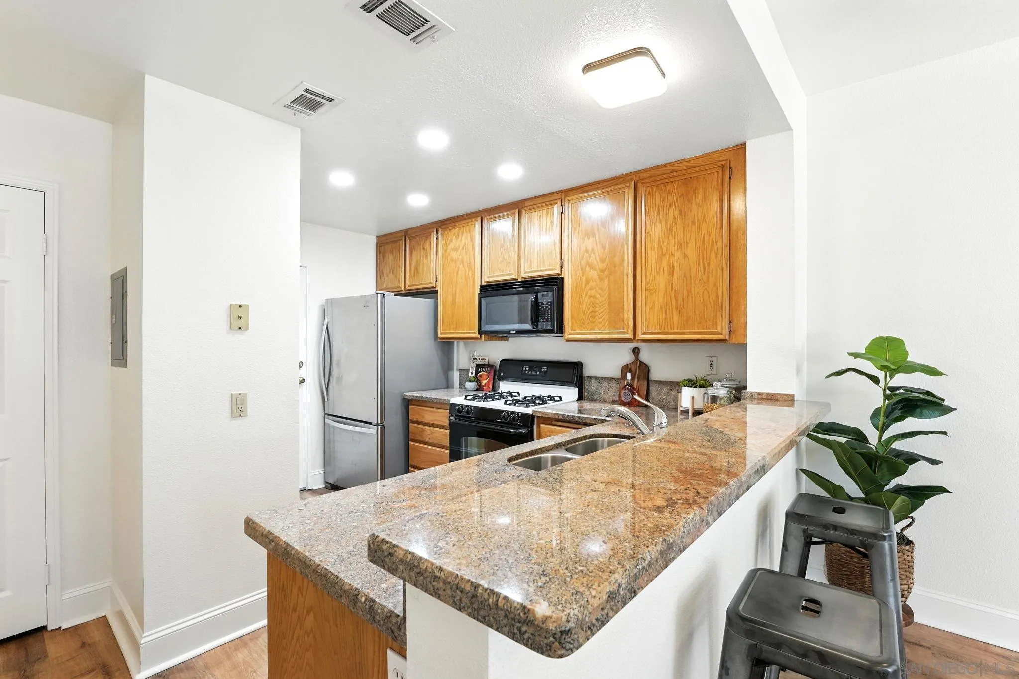 29581 Cara Way Temecula, CA 92591 - Photo 8 of 24 a kitchen with stainless steel appliances granite countertop a refrigerator a sink a stove and a wooden floors
