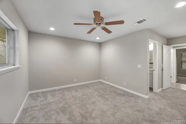 an empty room with closet and fan