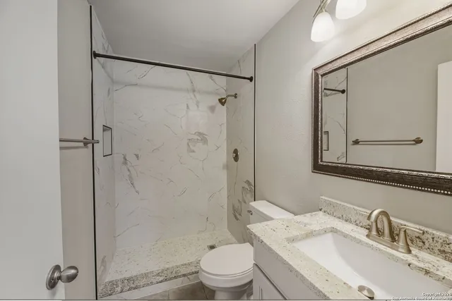 a bathroom with a sink toilet and shower