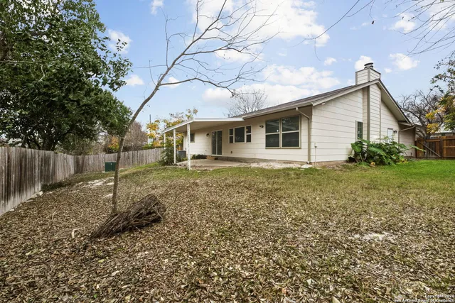 a white house that has a tree in front of it