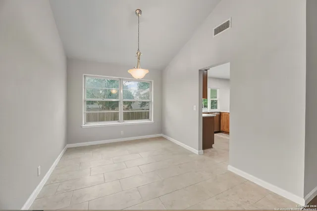 a view of an empty room with windows and cabinet