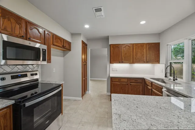 a kitchen with stainless steel appliances granite countertop a stove and a sink