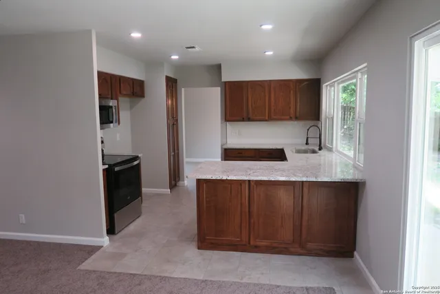 a kitchen with kitchen island a counter top space cabinets and stainless steel appliances