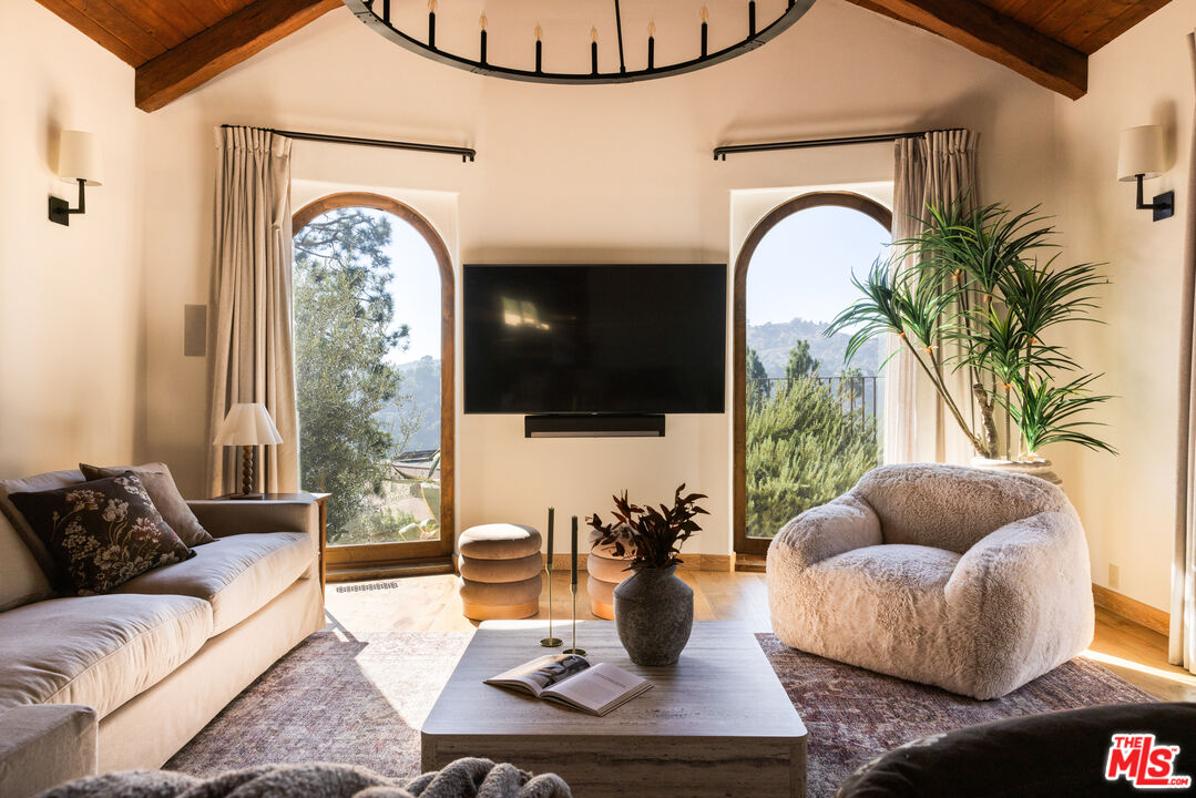 7935 Oceanus Drive Los Angeles, CA 90046 - Photo 10 of 43 a living room with furniture a fireplace and a flat screen tv