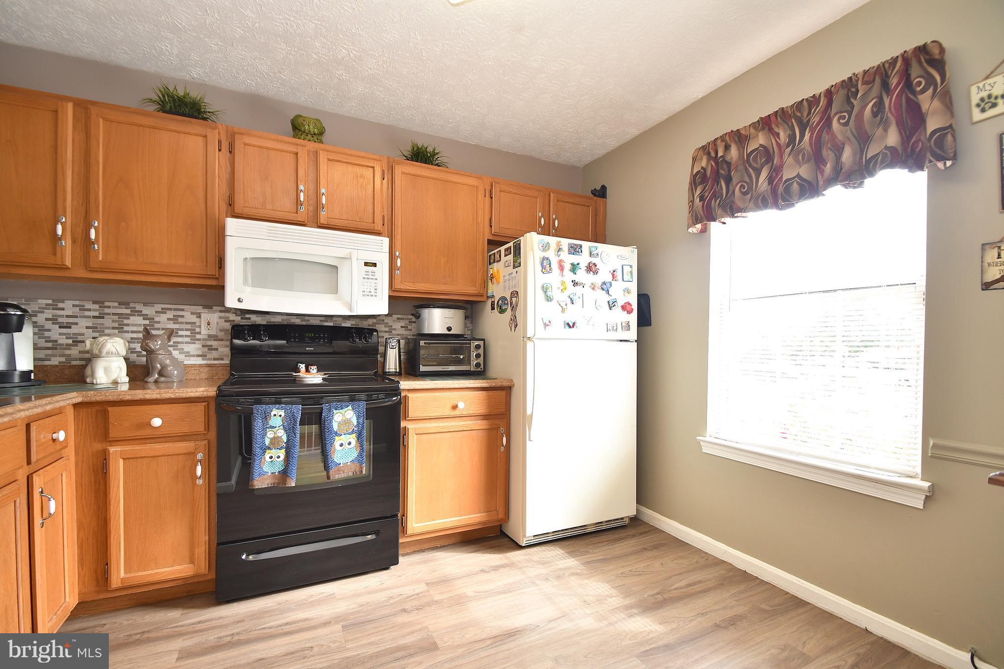 3924 Cutty Sark Road Baltimore, MD 21220 - Photo 5 of 30 a kitchen with stainless steel appliances a refrigerator and a stove top oven