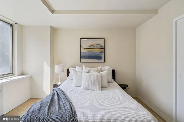 a bedroom with a bed and painting on the wall