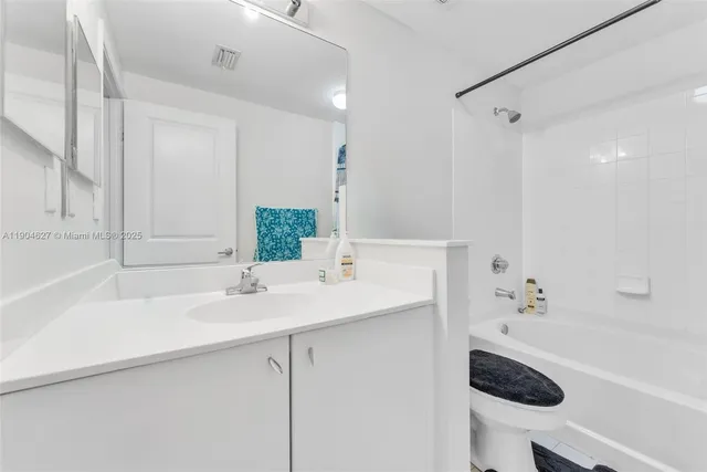 a bathroom with a sink a toilet a shower and a mirror