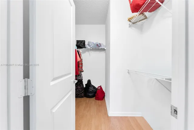 a view of walk in closet with clothes and shoes