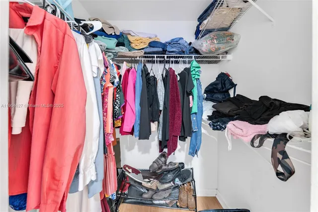 a view of walk in closet with clothes