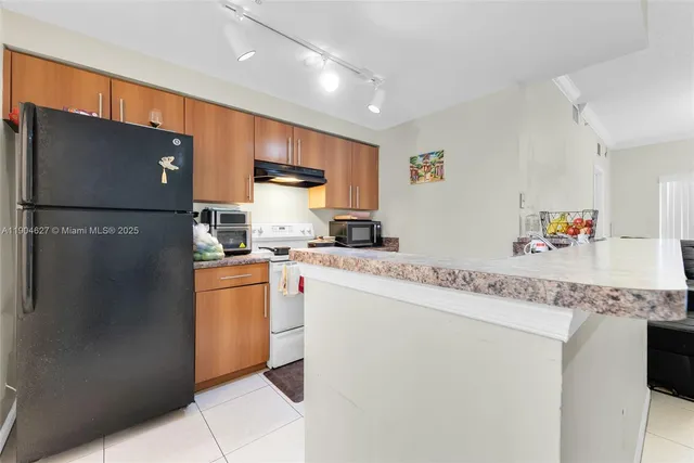 a kitchen with stainless steel appliances granite countertop a refrigerator sink and cabinets