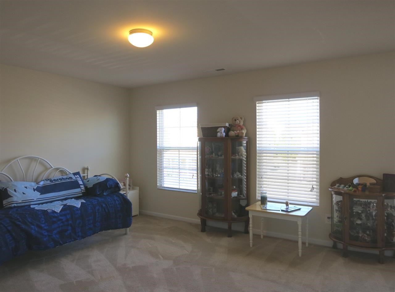 3808 Althorp Drive Raleigh, NC 27616 - Photo 19 of 25 Nearby is the Laundry Rm w/neutral vinyl flr & shelving, and 2 add'l lg Bedrooms w/neutral carpet & lg WICs, which share the family Bath. This is spacious Bedroom 2 w/3 windows.