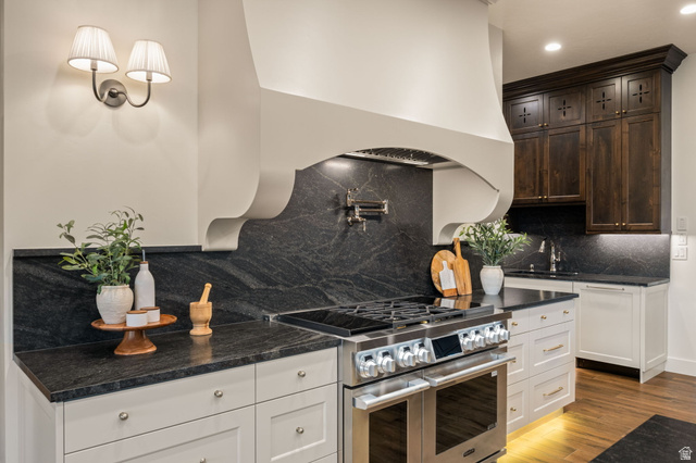 4871 South Homestead Way Washington, UT 84780 - Photo 29 of 151 Kitchen with range with two ovens, light wood finished floors, dark stone counters, recessed lighting, and backsplash
