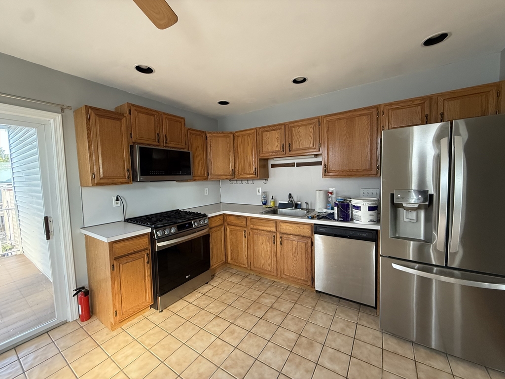 a kitchen with granite countertop a refrigerator stove top oven and sink