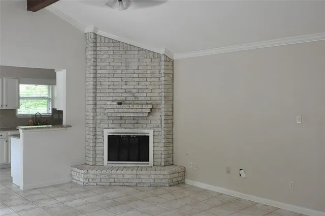 a view of an empty room with a fireplace and a window