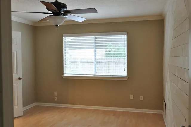 an empty room with a window and a fan