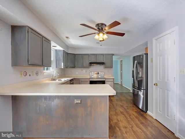 a kitchen with stainless steel appliances granite countertop a sink a stove and a refrigerator