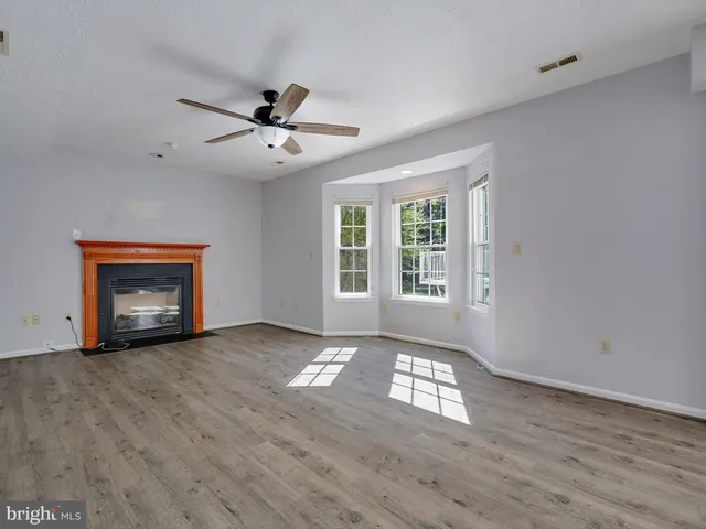 a view of an empty room with a window and fireplace
