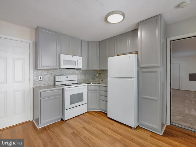 a kitchen with a refrigerator sink and cabinets