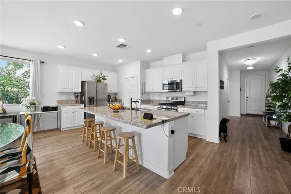 a kitchen with appliances a sink a counter top space and a center island