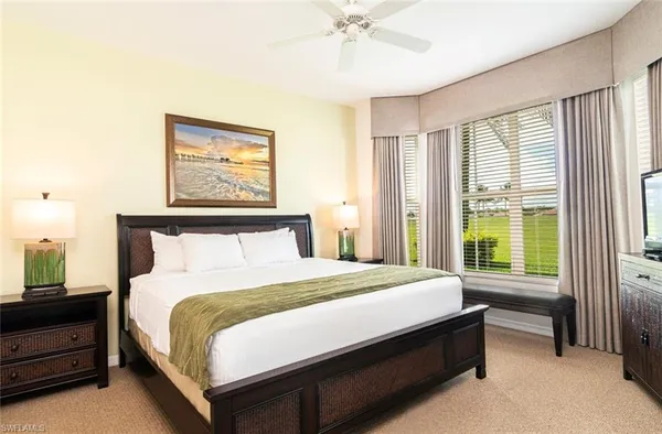 a large bed sitting in a bedroom next to a window