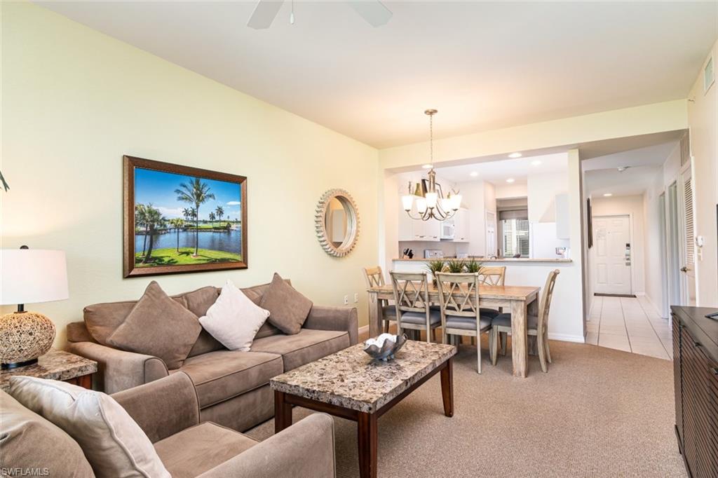 7955 Mahogany Run Lane, Unit 515 Naples, FL 34113 - Photo 4 of 20 a living room with furniture and a chandelier