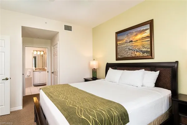 a bedroom with a bed and a painting on the wall