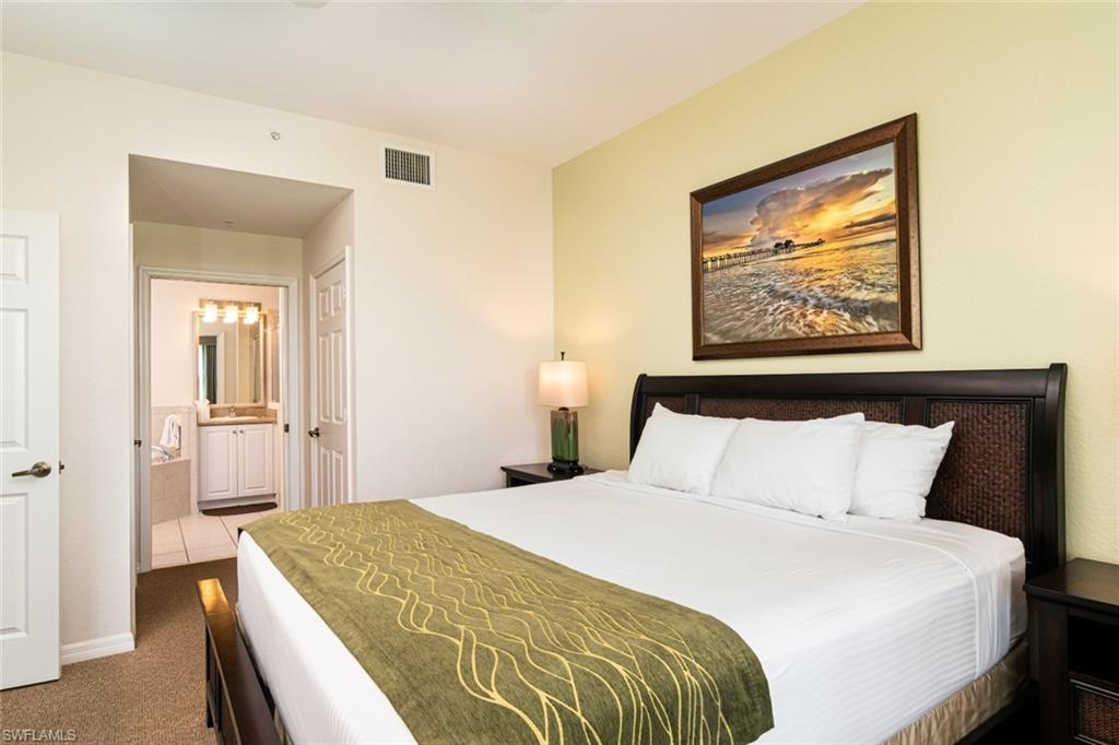 7955 Mahogany Run Lane, Unit 515 Naples, FL 34113 - Photo 6 of 20 a bedroom with a bed and a painting on the wall