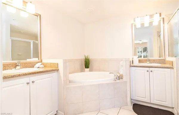 a bathroom with a tub sink and a mirror