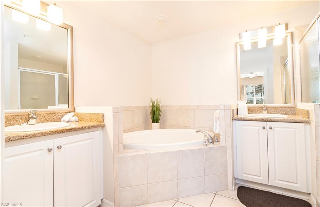 7955 Mahogany Run Lane, Unit 515 Naples, FL 34113 - Photo 7 of 20 a bathroom with a tub sink and a mirror