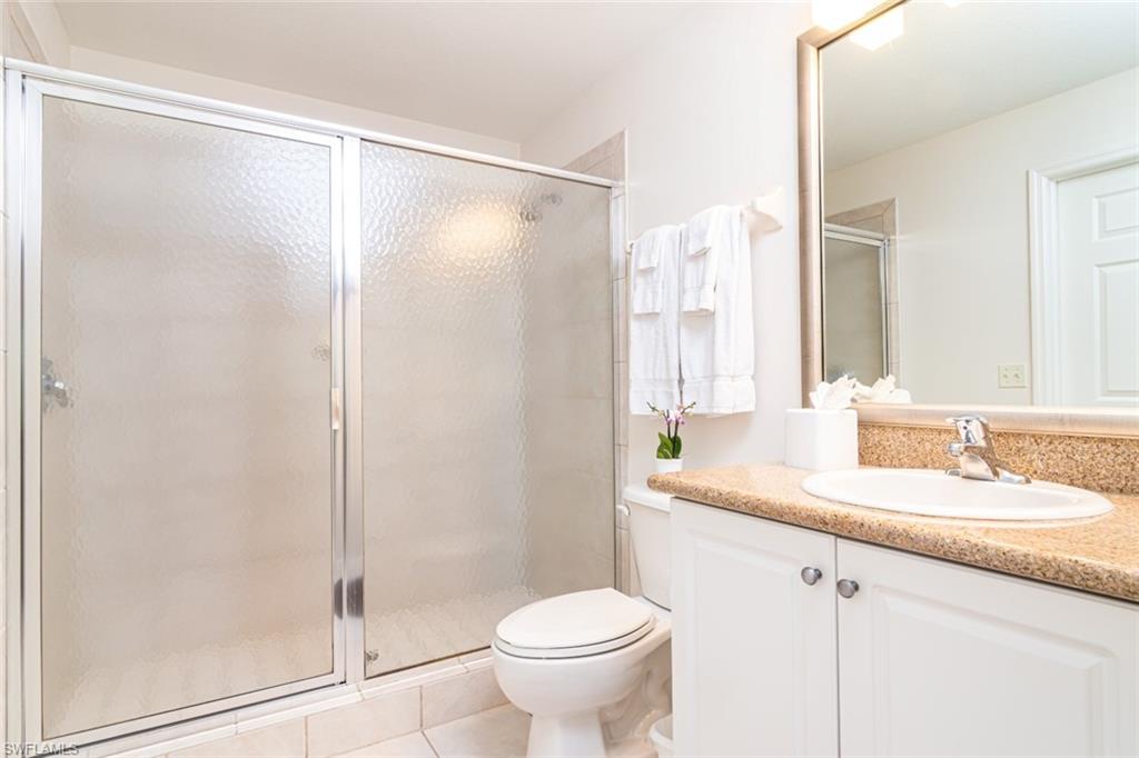 7955 Mahogany Run Lane, Unit 515 Naples, FL 34113 - Photo 9 of 20 a bathroom with a granite countertop sink toilet and shower