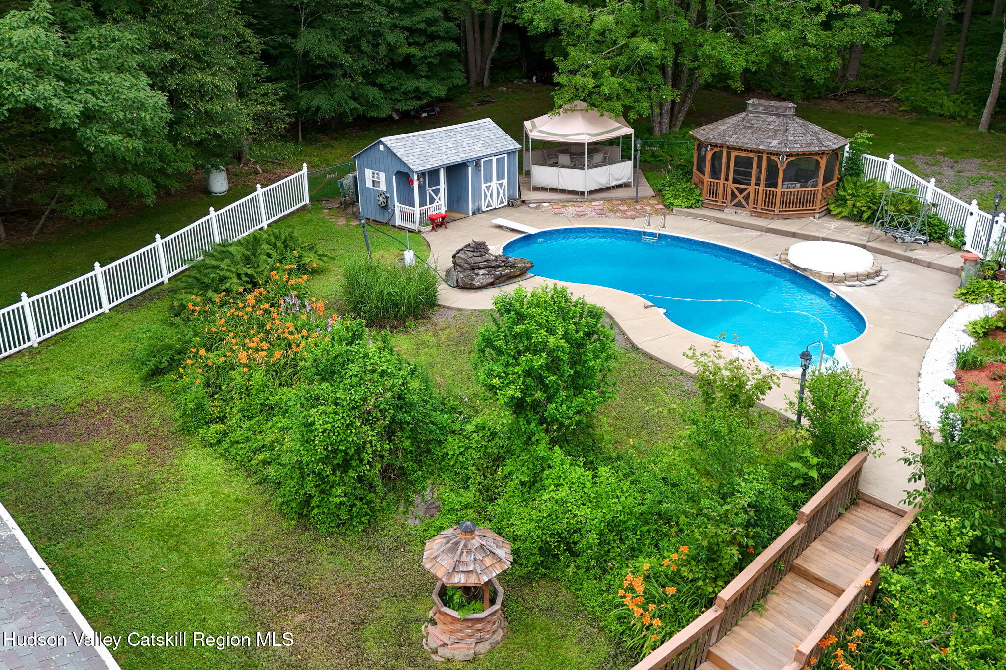 a aerial view of a house with swimming pool garden view and trees