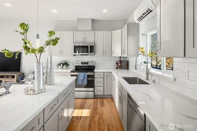 a kitchen with a sink a counter top space cabinets and appliances
