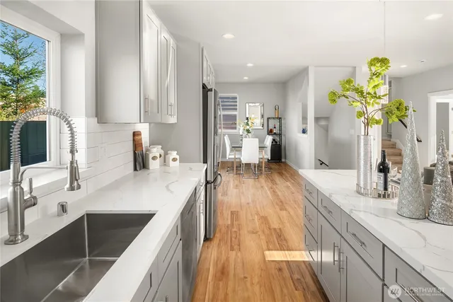 a view of a kitchen with kitchen island a counter top space a sink and cabinets