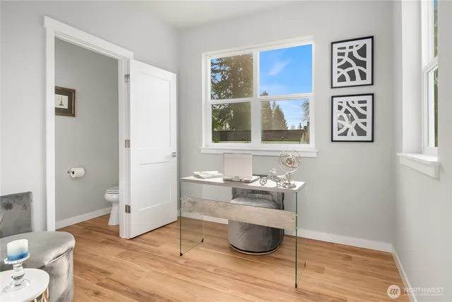 a view of a room with wooden floor and furniture