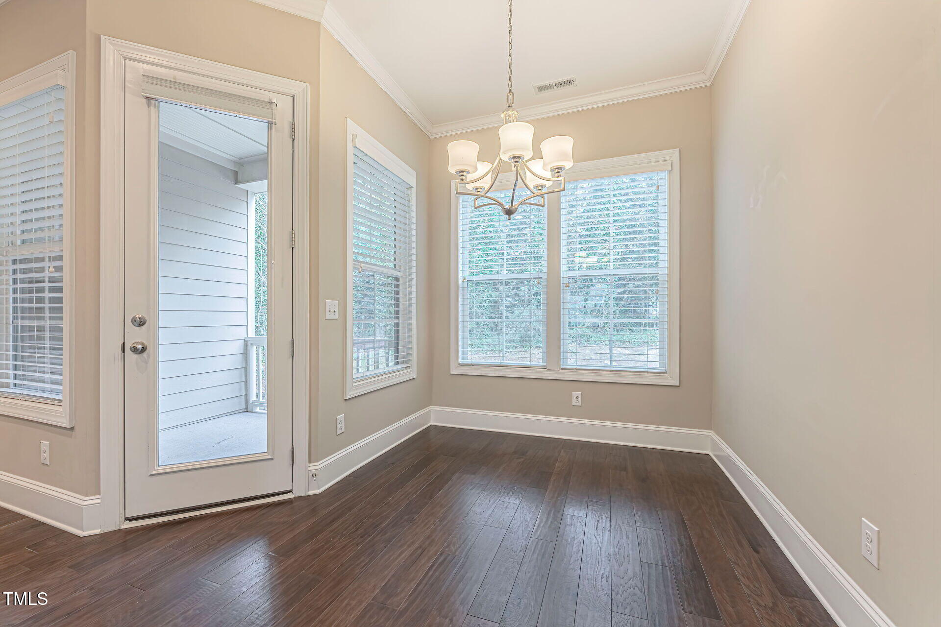 3606 Winifred Way Raleigh, NC 27609 - Photo 18 of 45 an empty room with wooden floor chandelier and glass door