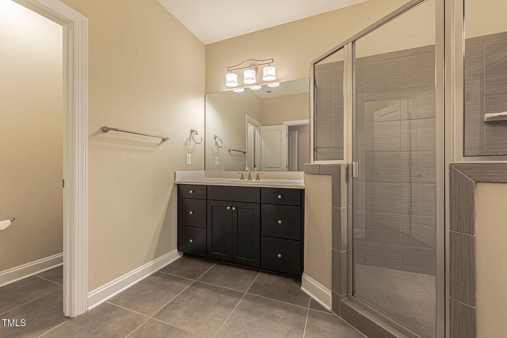3606 Winifred Way Raleigh, NC 27609 - Photo 35 of 45 a bathroom with a granite countertop sink a mirror and a shower