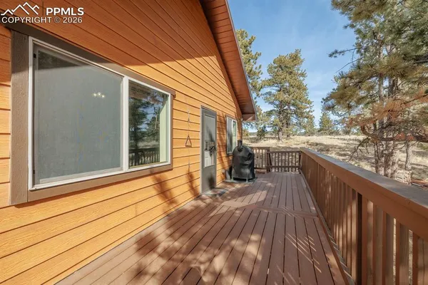 a view of a balcony with wooden floor and fence