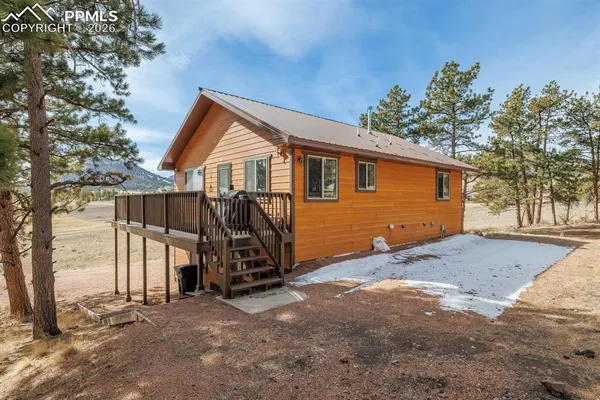 a view of a house with a yard and wooden fence