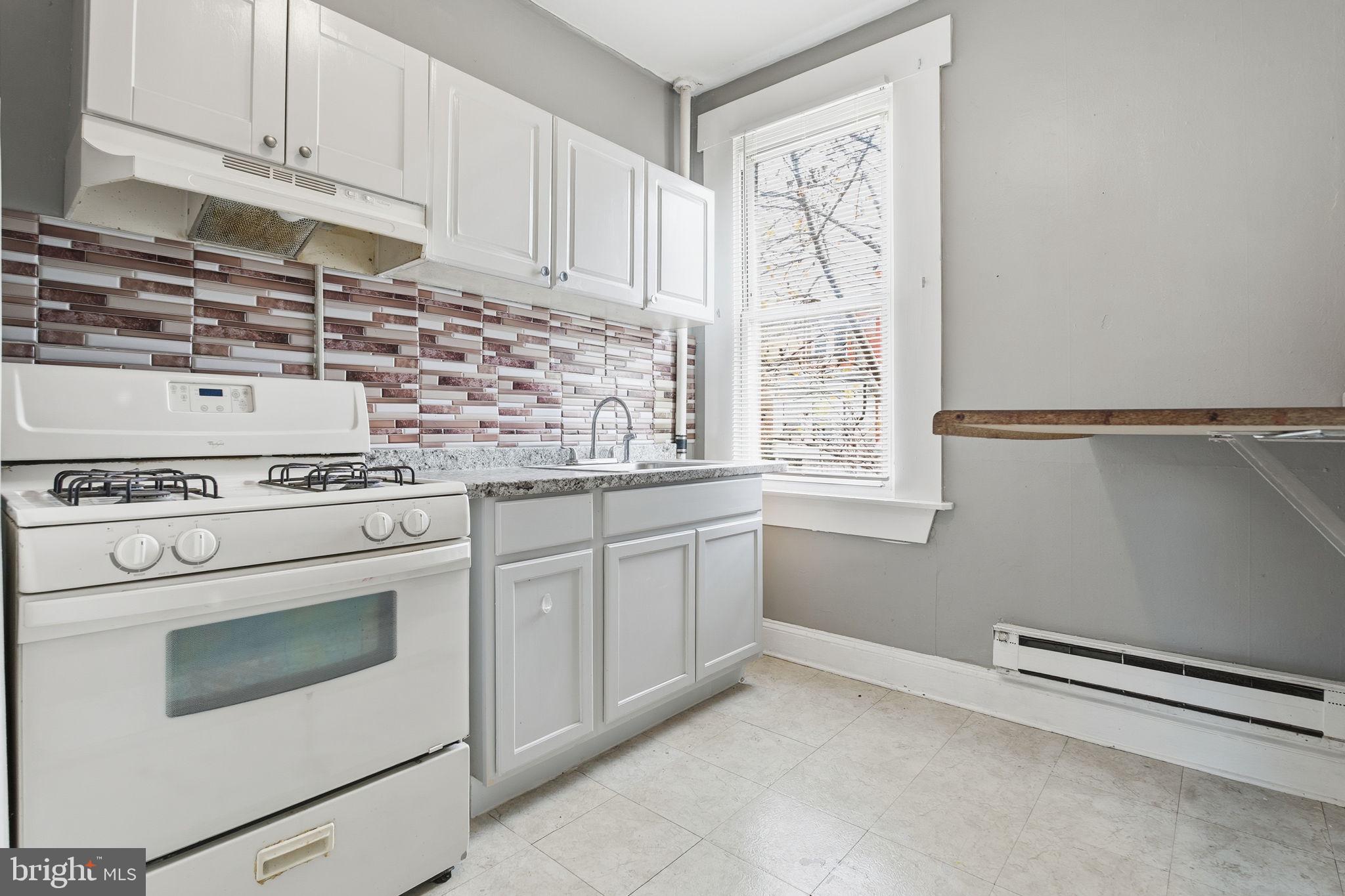 a kitchen with granite countertop white cabinets and white appliances