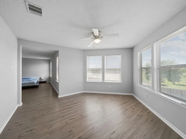 a view of a room with wooden floor and a window