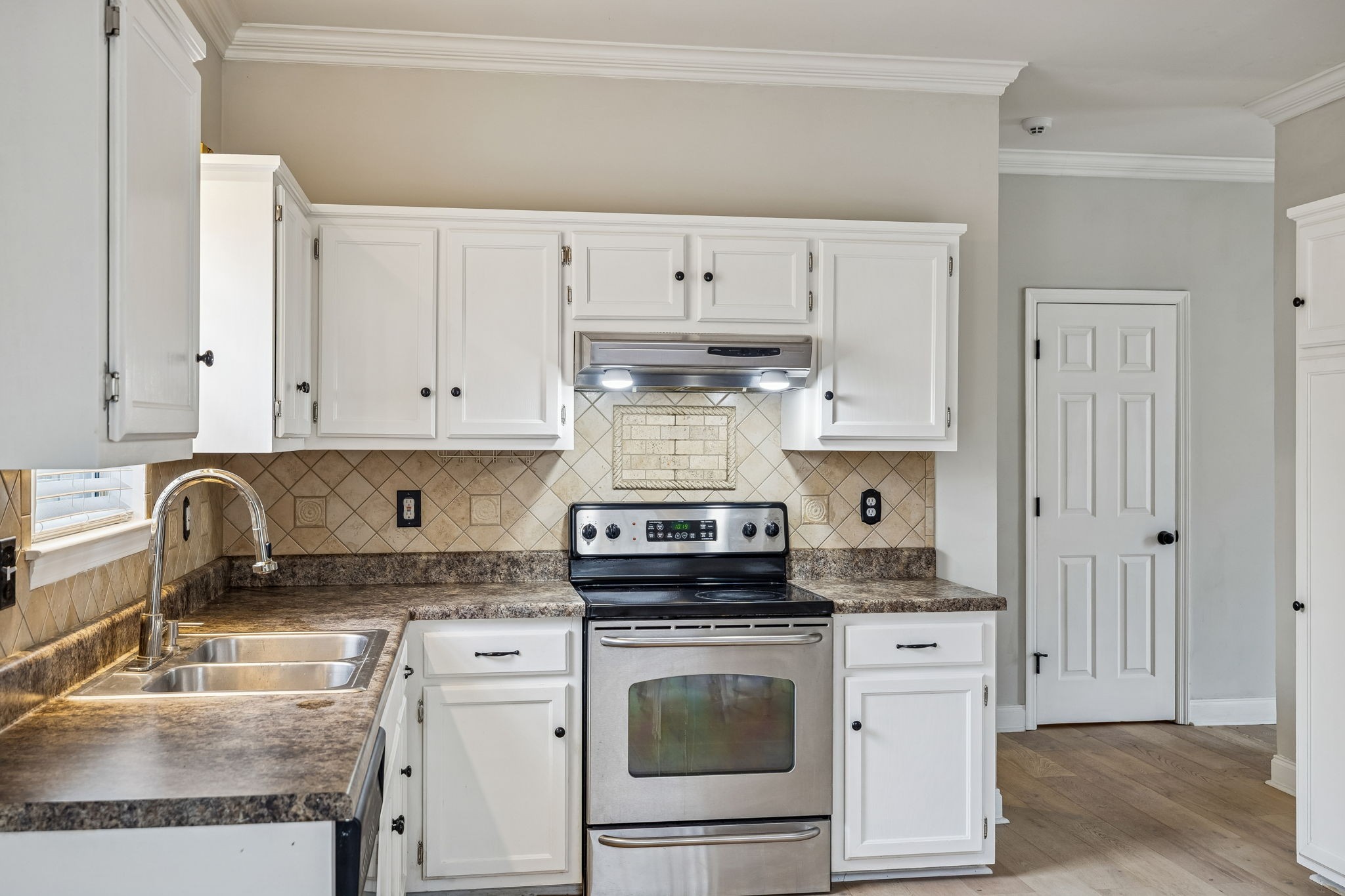 7701 Poplar Ridge Drive Nashville, TN 37221 - Photo 12 of 28 a kitchen with granite countertop white cabinets sink and stainless steel appliances
