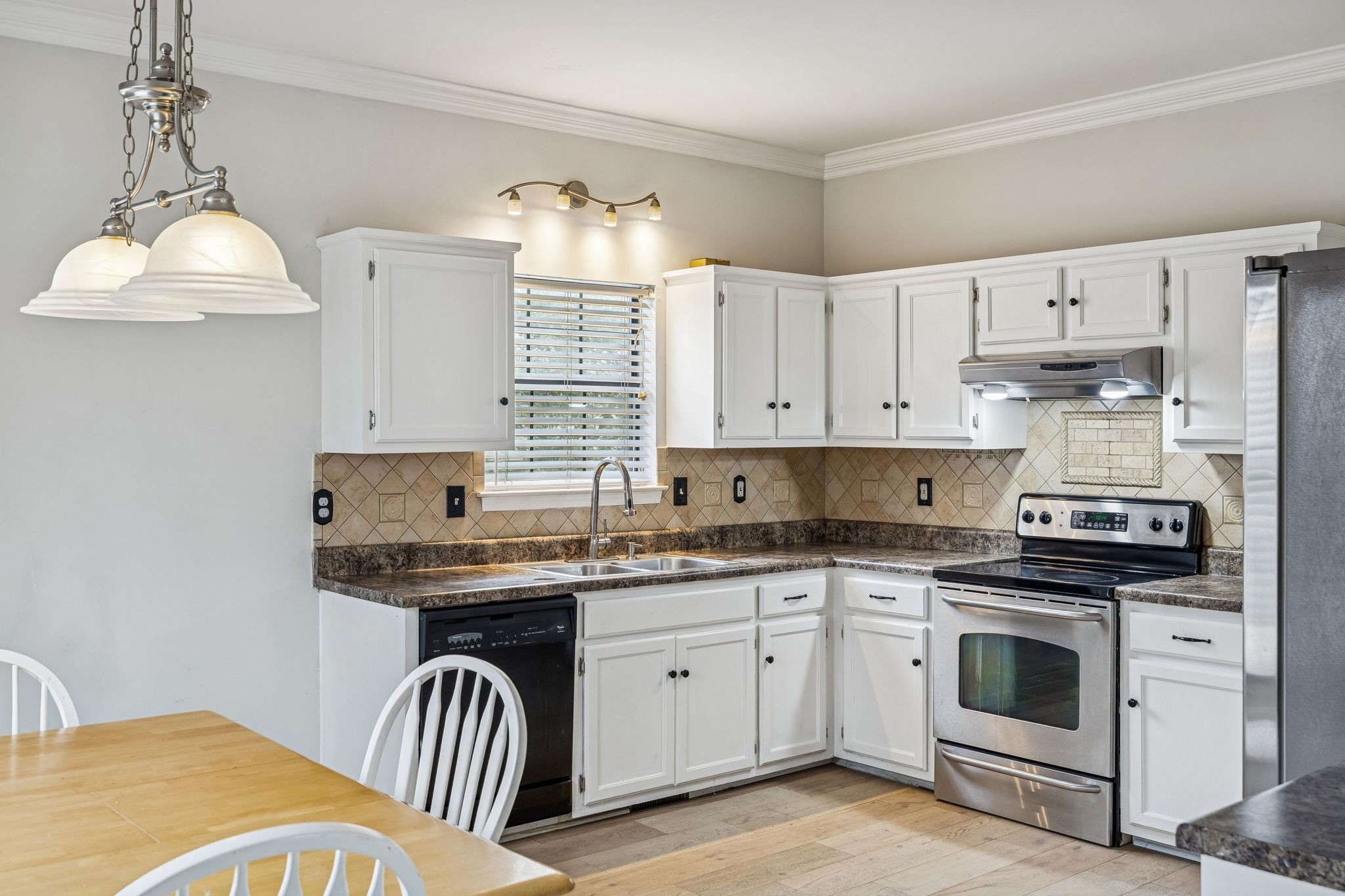 7701 Poplar Ridge Drive Nashville, TN 37221 - Photo 8 of 28 a kitchen with stainless steel appliances granite countertop a sink a stove a dining table and chairs