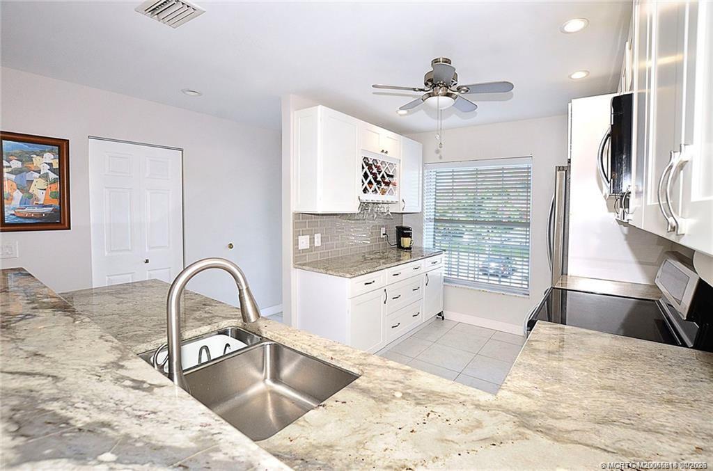 1854 Southwest Palm City Road, Unit 203 Stuart, FL 34994 - Photo 12 of 38 a kitchen with stainless steel appliances kitchen island a stove a sink and a refrigerator