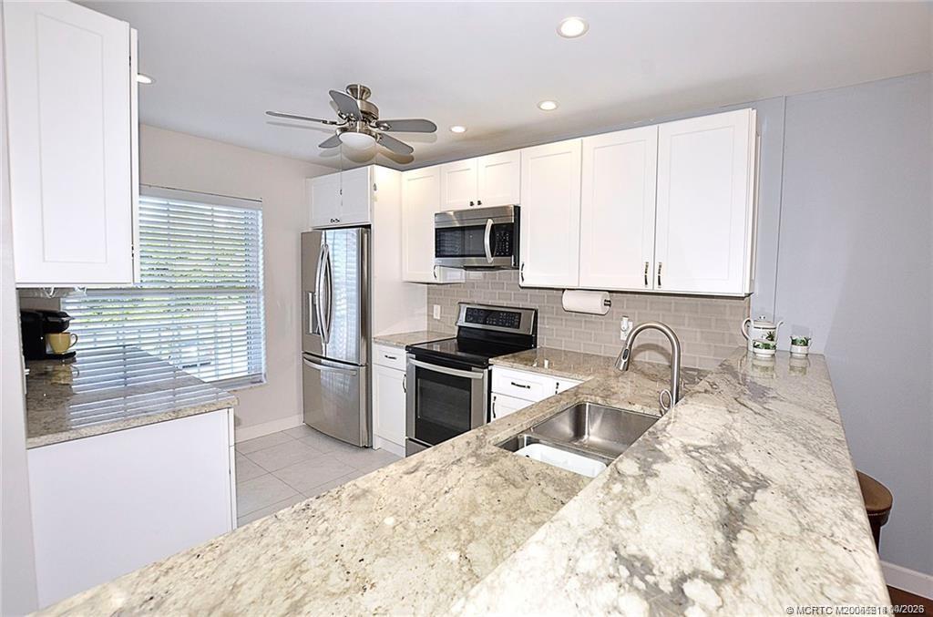1854 Southwest Palm City Road, Unit 203 Stuart, FL 34994 - Photo 15 of 38 a kitchen with a appliances sink cabinets and window