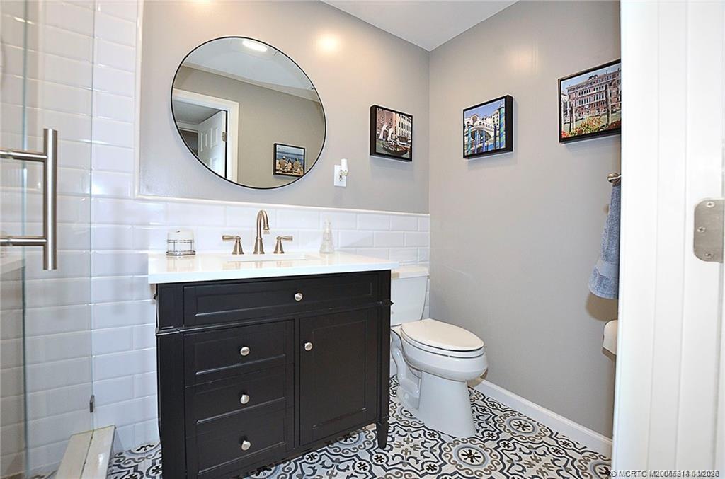 1854 Southwest Palm City Road, Unit 203 Stuart, FL 34994 - Photo 23 of 27 Step into this beautifully renovated bathroom with a sleek glass-enclosed shower, timeless subway tile, and designer finishes that create a fresh, spa-like feel